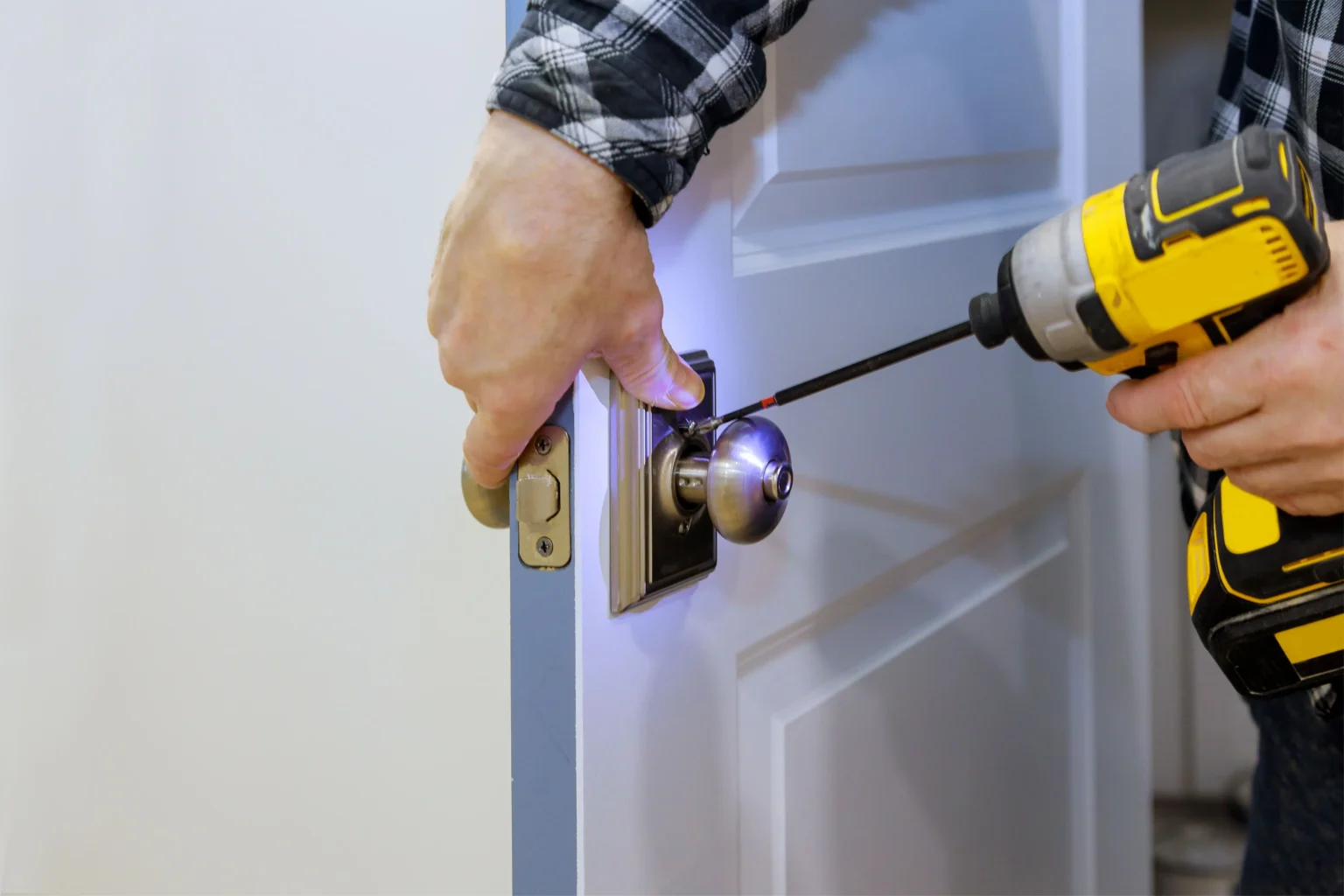 maitre-avec-tournevis-installe-l-acces-a-la-nouvelle-serrure-de-la-porte-de-la-chambre-dans-la-maison